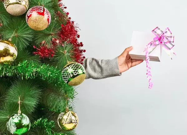 A person holding a cute Xmas present with a pink ribbon