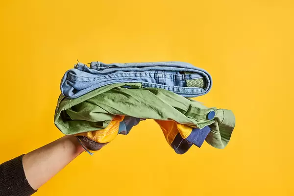 A person holding brand new clothes set