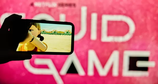 A person holding phone and watching Netflix series Squid Game