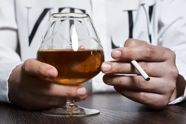 A person with brandy and cigarette