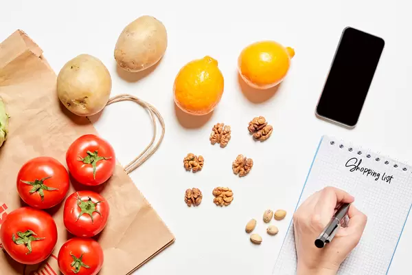 A person writing a grocery shopping list