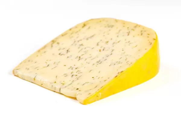 A piece of Dutch cheese with herbs and garlic on a white background
