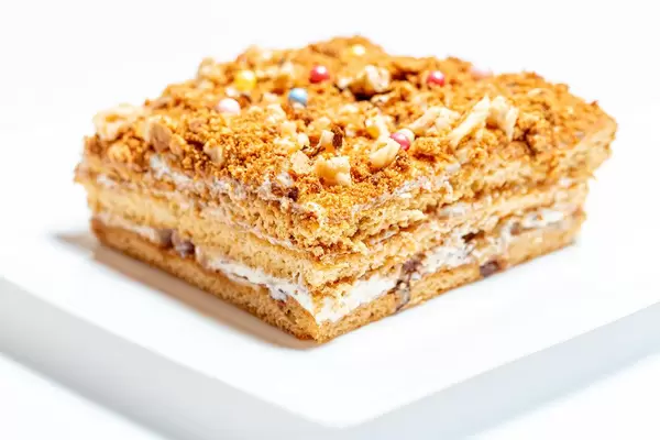 A piece of fresh honey cake on a white plate (Flip 2020)