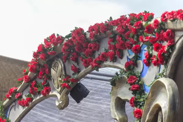 A piece of installation covered by red rose with the Tomorrowland logo on it
