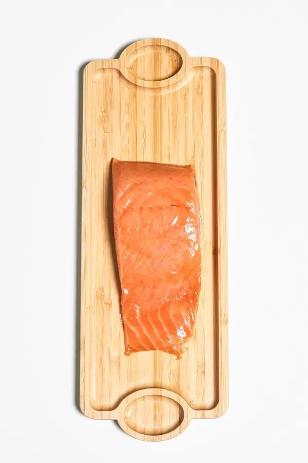 A piece of Red fish salmon meat on the long wooden plate