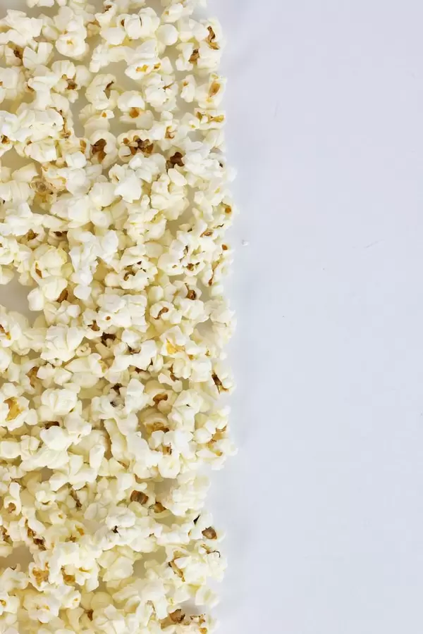 A pile of popping popcorn against a white background