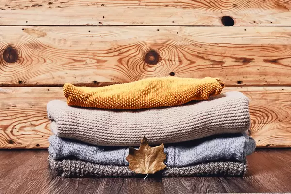 A pile of pullovers on wooden desk