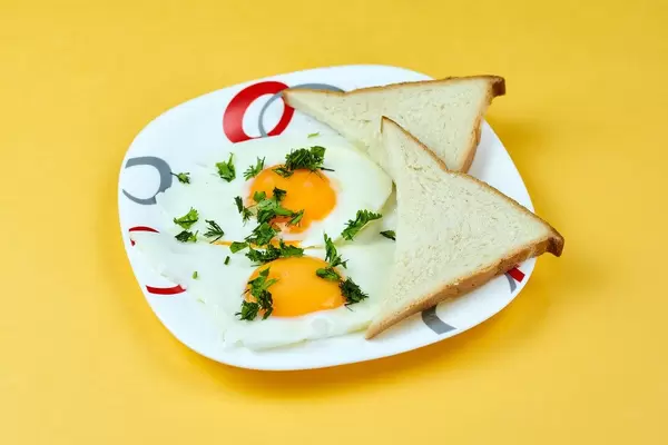 A plate of fried eggs and toasts for breakfast