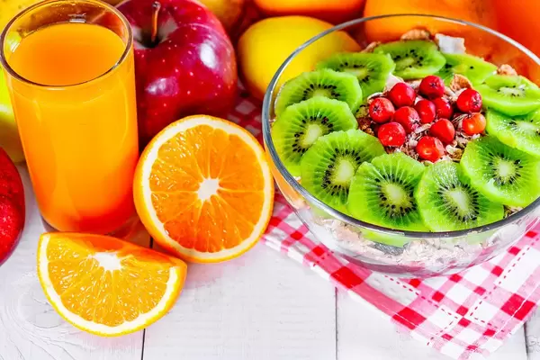 A proper Breakfast: fruit oranges, apples, pears, lemons, a glass of juice and a plate of oatmeal