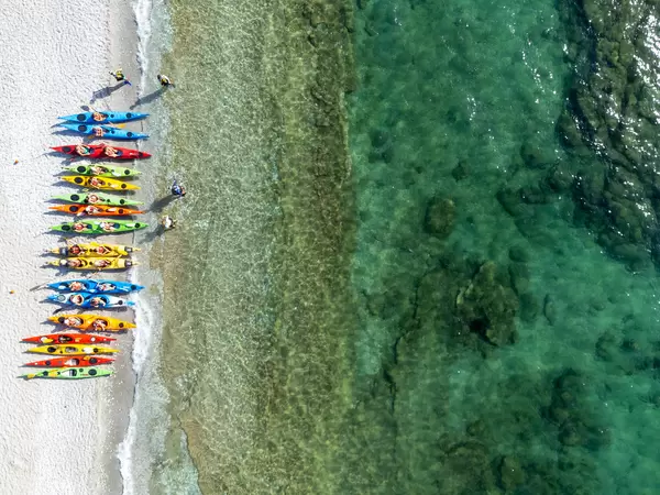 A row of kayaks in various colours on Milia Beach, Skopelos. Bird's eye view on tropical-like beach
