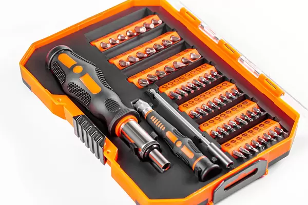 A set of screwdrivers and bits in an orange box