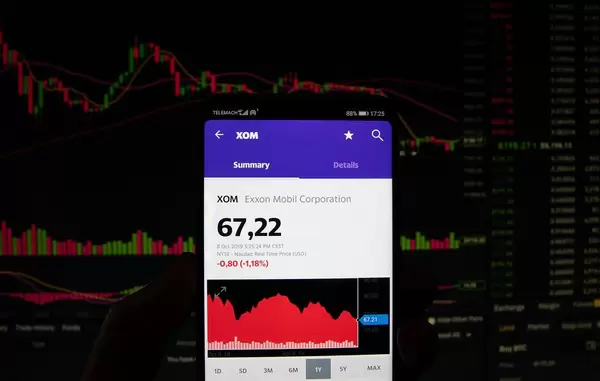 A smartphone displays the Exxon Mobil Corporation market value