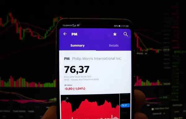 A smartphone displays the Philip Morris International market value