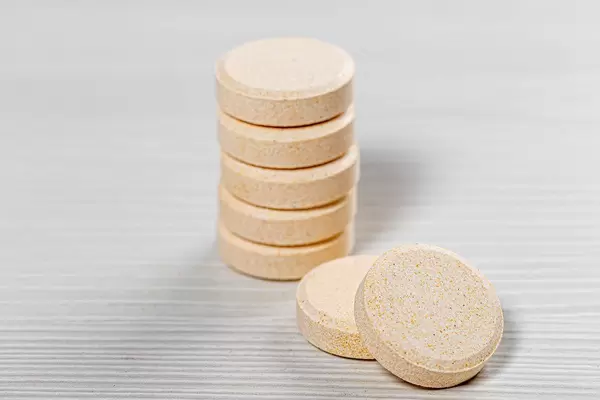 A stack of large pills on a white wooden background (Flip 2019)