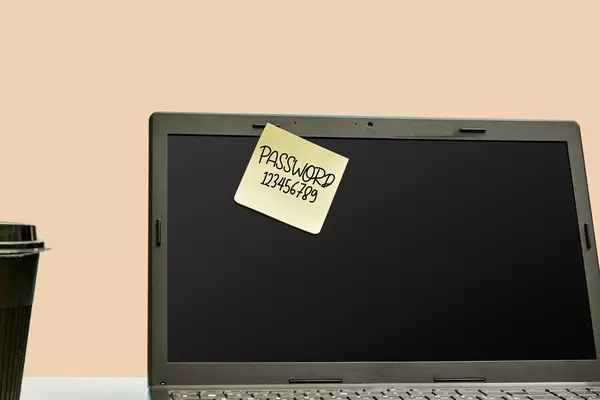 A sticky note with a password on the laptop