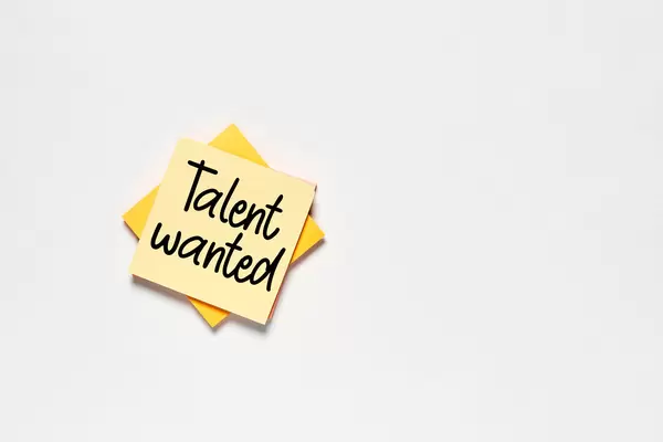 A sticky note with 'Talent wanted' text on white backdrop