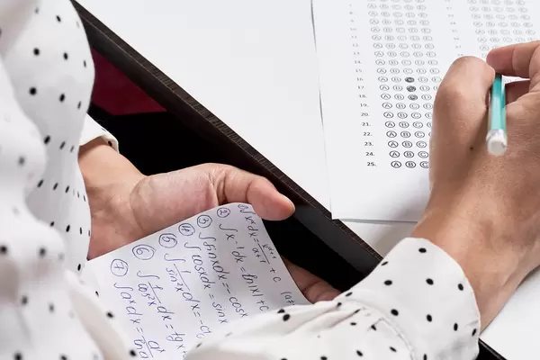 A student using math formula sheet to cheat on test