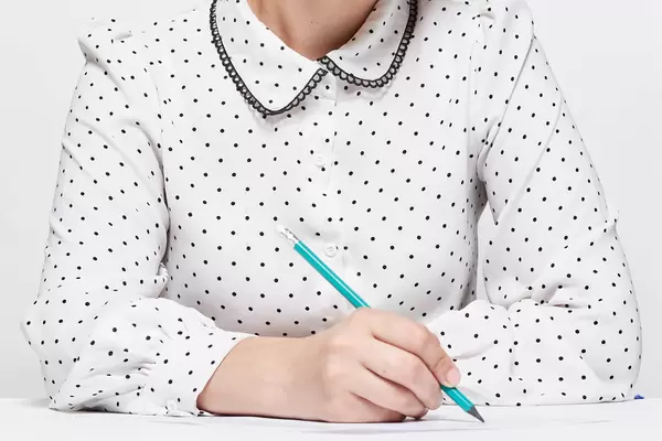 A teacher checking homework assignment and report on desk in school for score