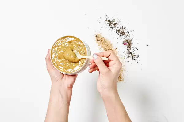 A woman holding herbal and organic cream