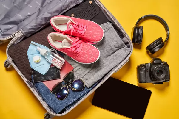 A woman packed a lot of her clothes and stuff into a suitcase and preparing for travel and journey trip