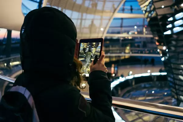 A woman taking picture inside Reichstag Dome with a tablet