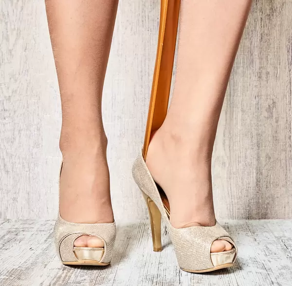 A young female wearing on new high heel shoes in boutique