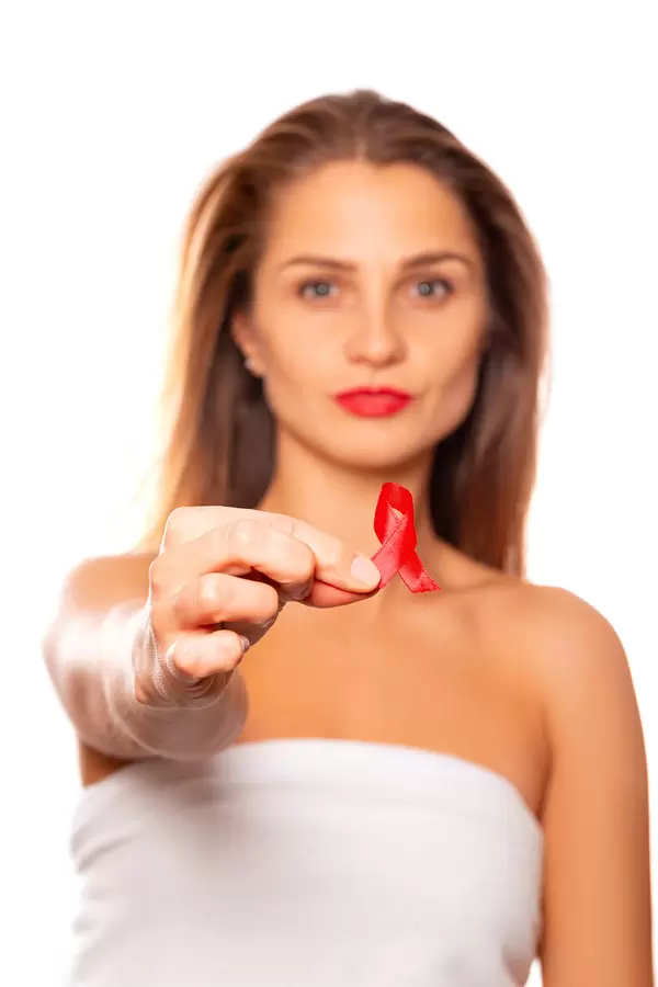 A young woman holds a red awareness ribbon in her hand