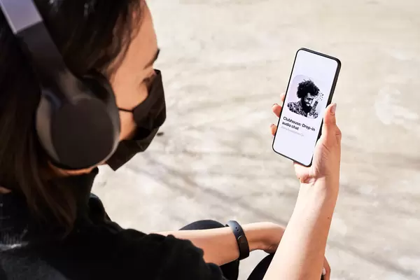 A young woman talking with Clubhouse audio chat app