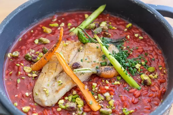 Abbaco, Port de Pollença. Nahaufnahme: Reis mit Rote-Bete-Sauce, Gemüse und Hühnerbrust