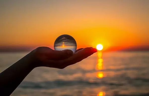 Abenddämmerung und Horizont spiegelt sich mit dem Meer in einem Glasball