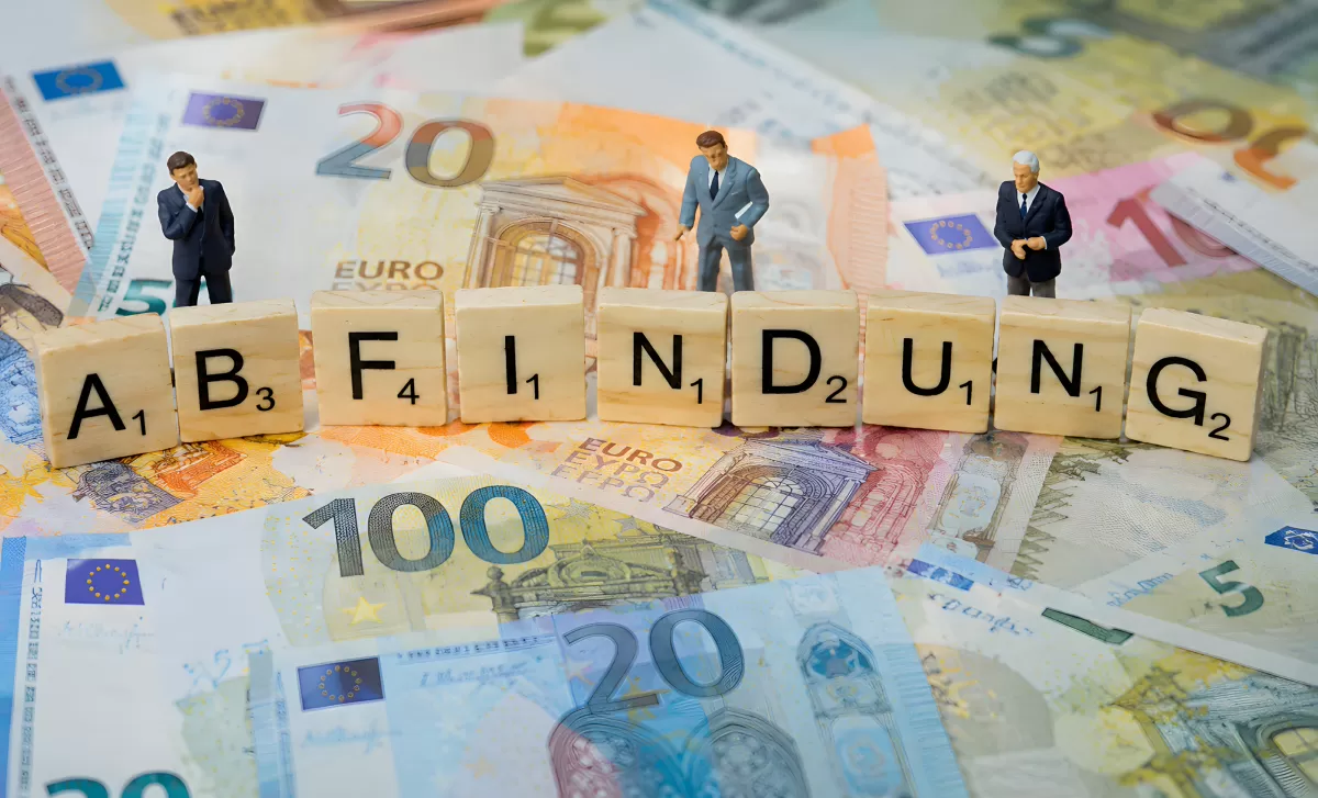 Abfindung in Euro – Scrabble-Buchstaben auf Geldscheinen