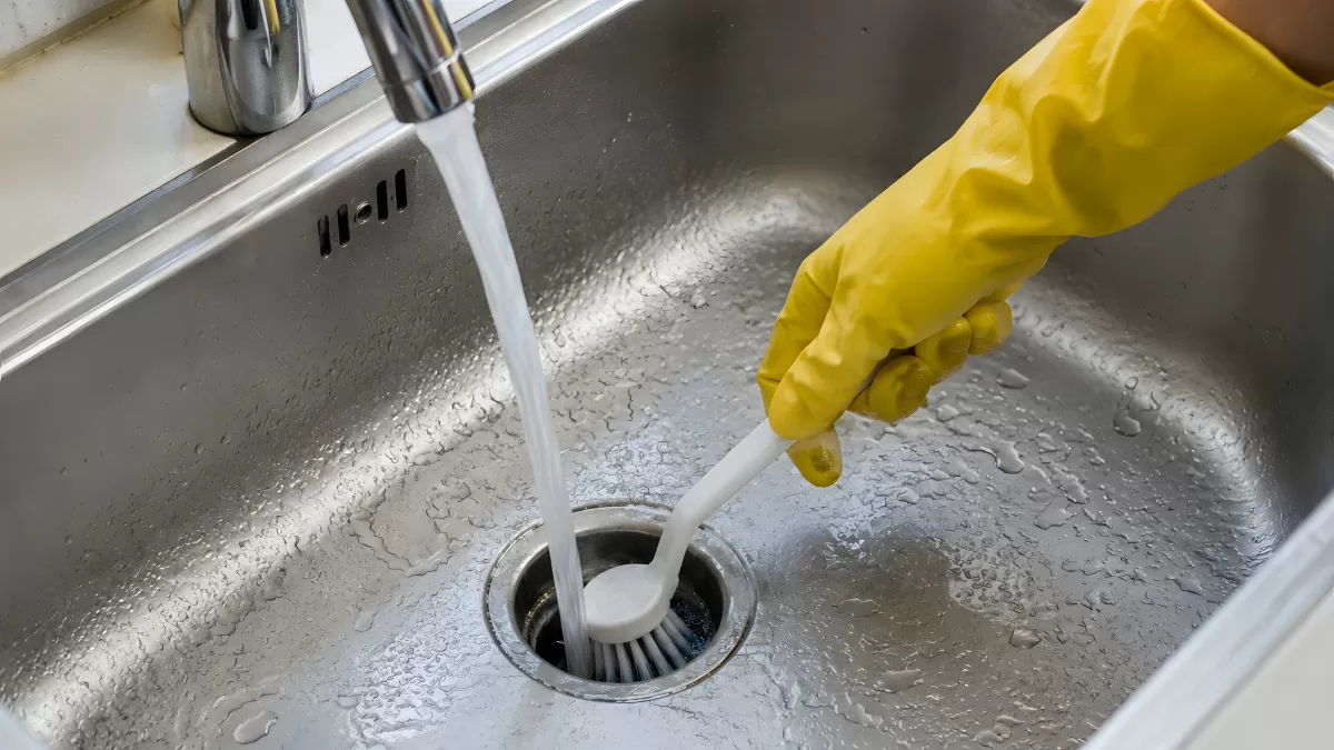 Abfluss reinigen mit Bürste und Gummihandschuh