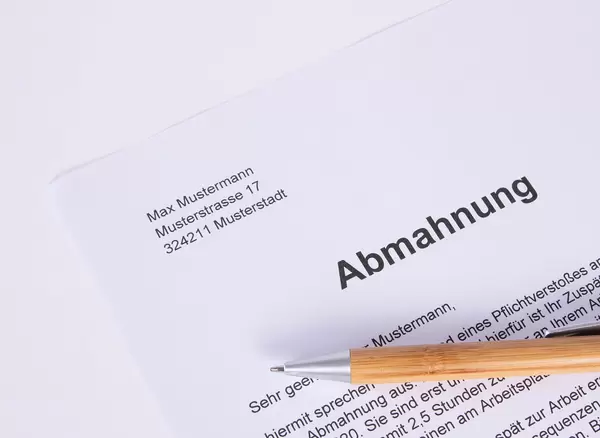 Abmahnung document with pen on white table