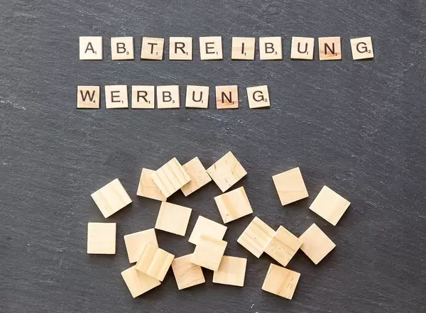 Abtreibung Werbung mit Holzplättchen auf schwarzer Oberfläche