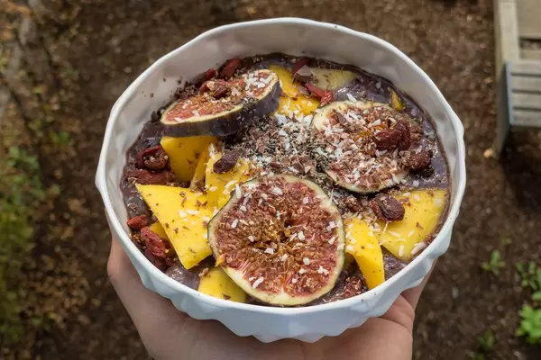 Acai Bowl mit Mango, Feige, Rosinen, Goji Beeren und Kokosraspeln. Nahaufnahme