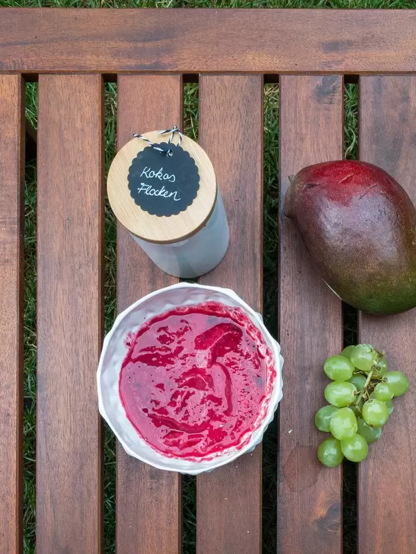 Acai-Grundmasse, Kokosflocken, Weintrauben und eine Mango