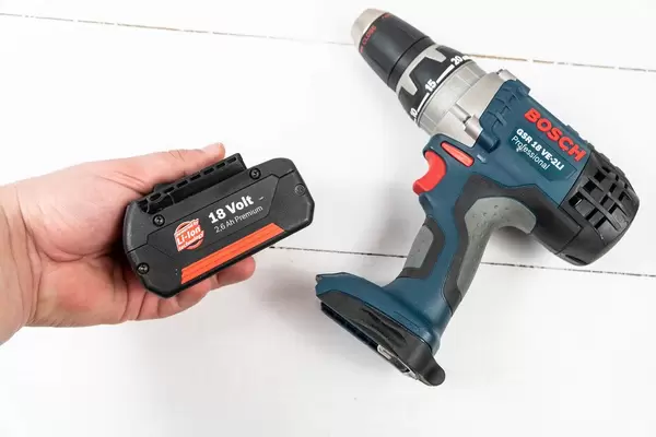 Accu Drill with battery in the hand above white background