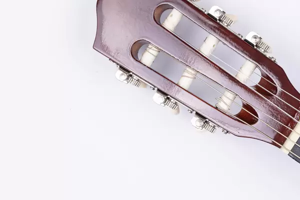 Acoustic Guitar Head above white background with copy space
