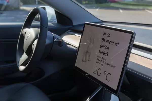 Active air conditioning in a parked Tesla for the dog mode: "My owner will be right back" - display text in German