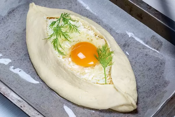 Adjarian khachapuri on a baking sheet ready for baking