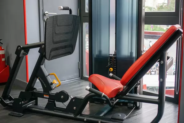 Adjustable Leg Press Machine with Incline Seat in a Gym Room