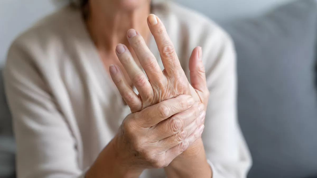 Ältere Frau hält sich schmerzende Hand – Arthritis