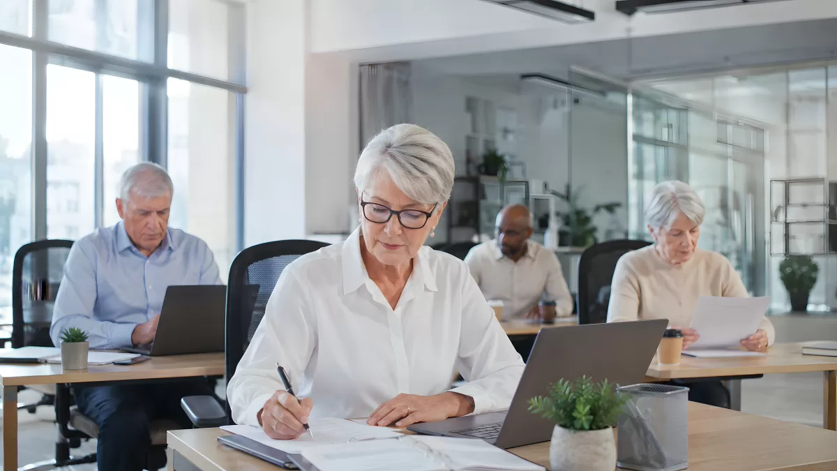Ältere Mitarbeiter arbeiten konzentriert im modernen Büro