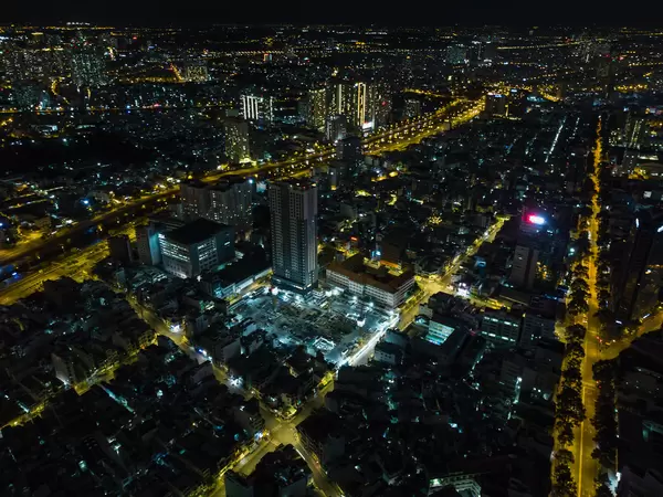 Aerial Drone Night Shot of Ho Chi Minh City, Vietnam with an Apartment Building Construction Site and many Buildings with no Traffic on the Streets