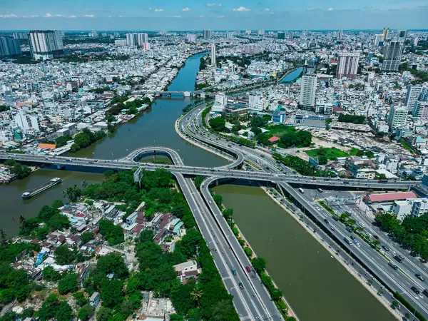Aerial Drone Photo of Creative Bridge System over Saigon River with many Buildings and different Districts in the Background in Ho Chi Minh City, Vietnam
