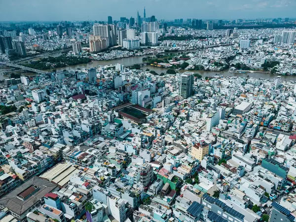Aerial Drone Photo of many Buildings and Houses in different Districts in front of the Skyline with Skyscrapers of Ho Chi Minh City, Vietnam