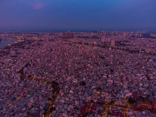 Aerial Drone Photo of many small Houses and Streets in District 4 in the Evening with Khanh Hoi Nha Rong Port at Saigon River in the Background in Ho Chi Minh City, Vietnam