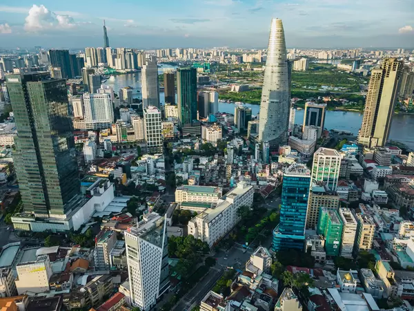 Aerial Drone Photo of the City Center of Ho Chi Minh City, Vietnam with Bitexco Financial Tower and Offices and Lanmark 81 and Saigon River in the Background