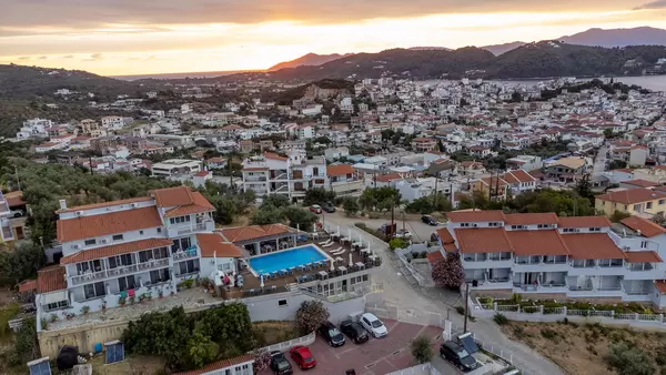 Aerial image of the Greek island of Skiathos with hotels and swimming pool in the foreground