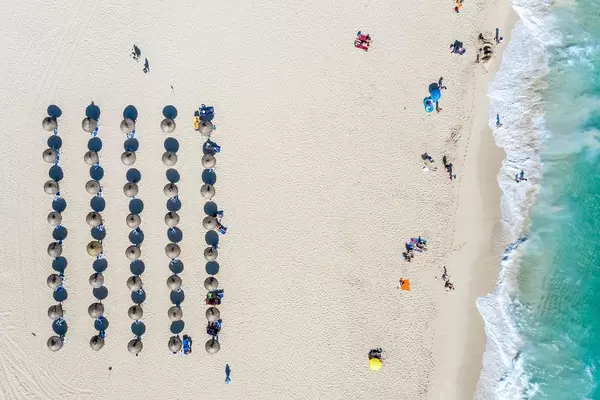 Aerial photo: Five rows of parasols cast their shadows on the sand. Cala Mesquida, Mallorca